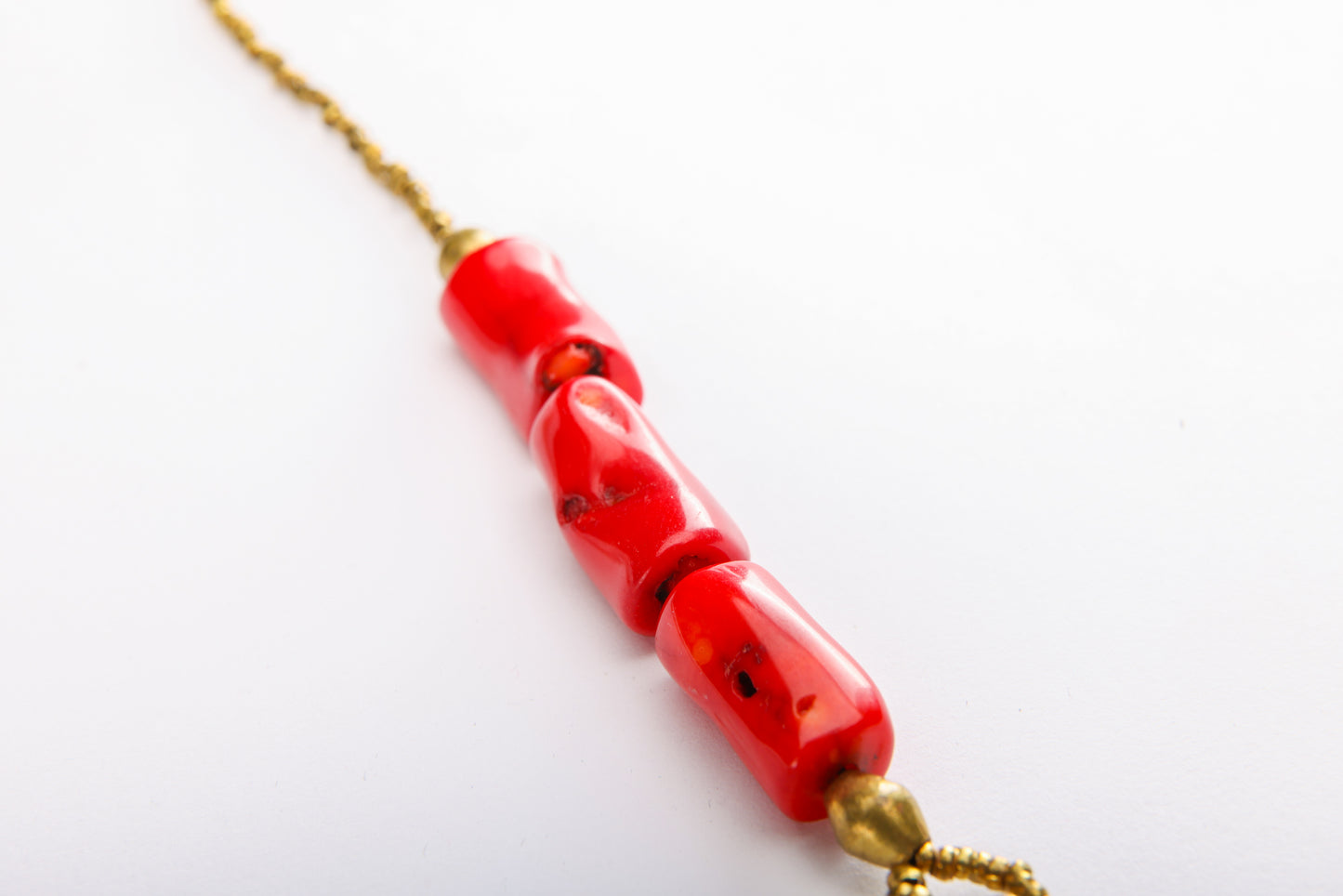 Close-up of natural coral beads and traditional Ethiopian brass beads on handcrafted cross necklace