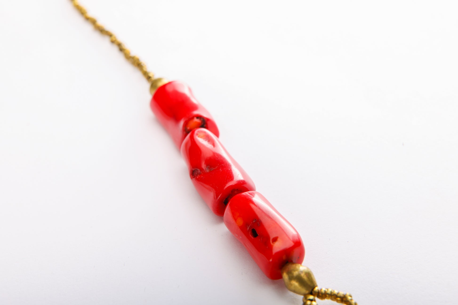 Close-up of natural coral beads and traditional Ethiopian brass beads on handcrafted cross necklace