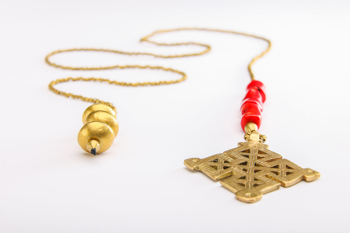 Full view and close-up of Ethiopian cross necklace featuring detailed cross, coral beads, and weighted end