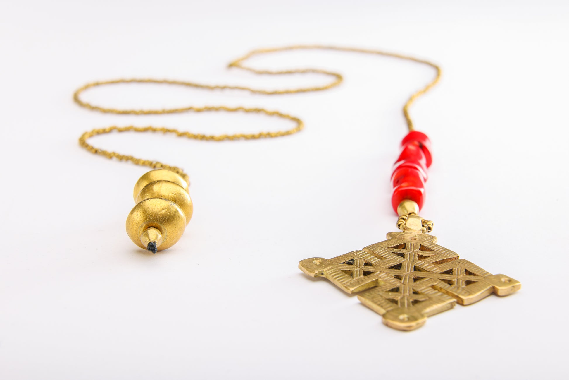 Full view and close-up of Ethiopian cross necklace featuring detailed cross, coral beads, and weighted end